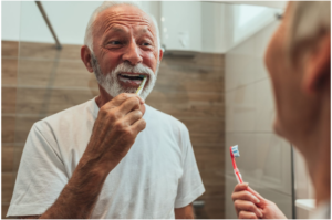 man and woman brushing teeth in bathroom