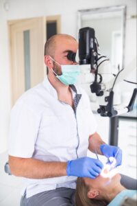 dentist using examination tool to look into patients tooth