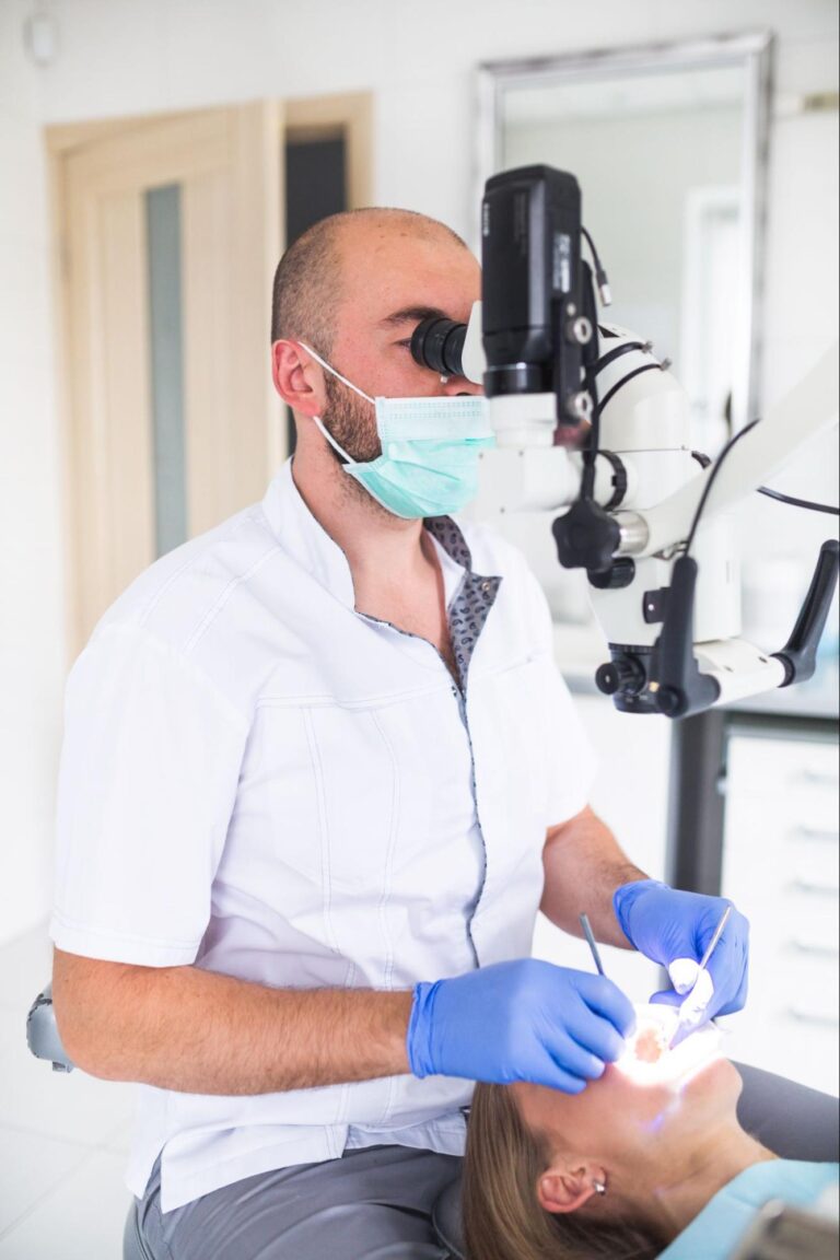 dentist using examination tool to look into patients tooth